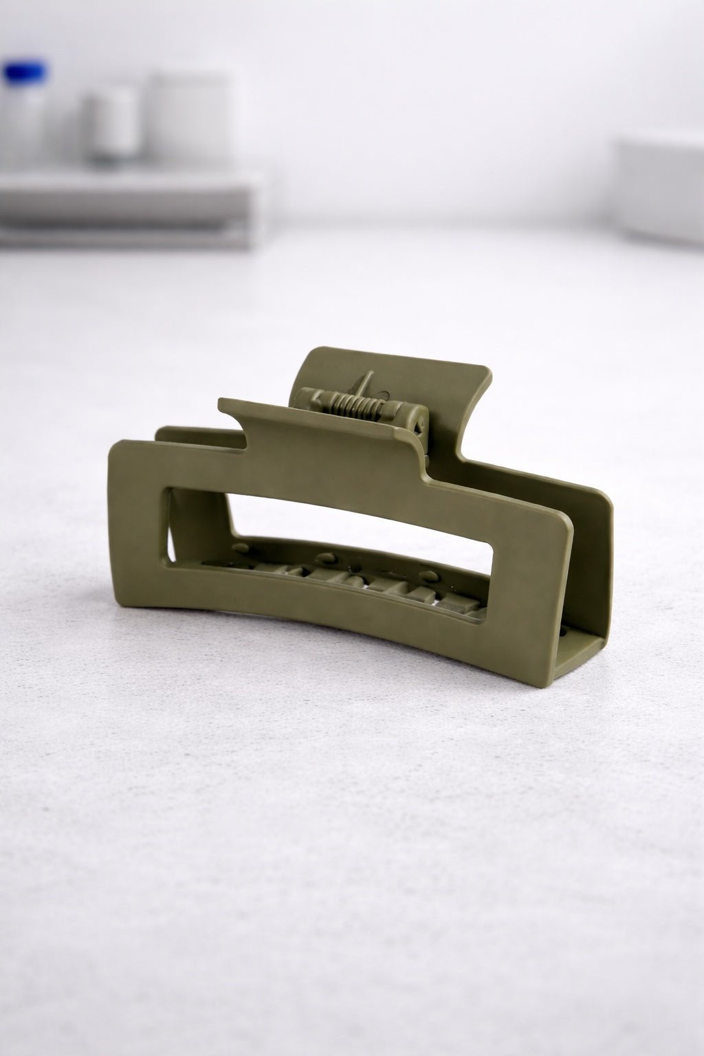 Oversized matte plastic hair claw clip shown closed, with wide curved jaws and evenly spaced teeth