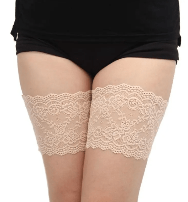 Beige lace anti-chafe thigh bands worn on the upper thighs to help prevent inner thigh chafing when wearing dresses.