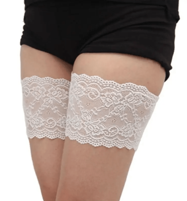 White lace anti-chafe thigh bands worn on the upper thighs to help prevent inner thigh chafing and improve dress comfort.